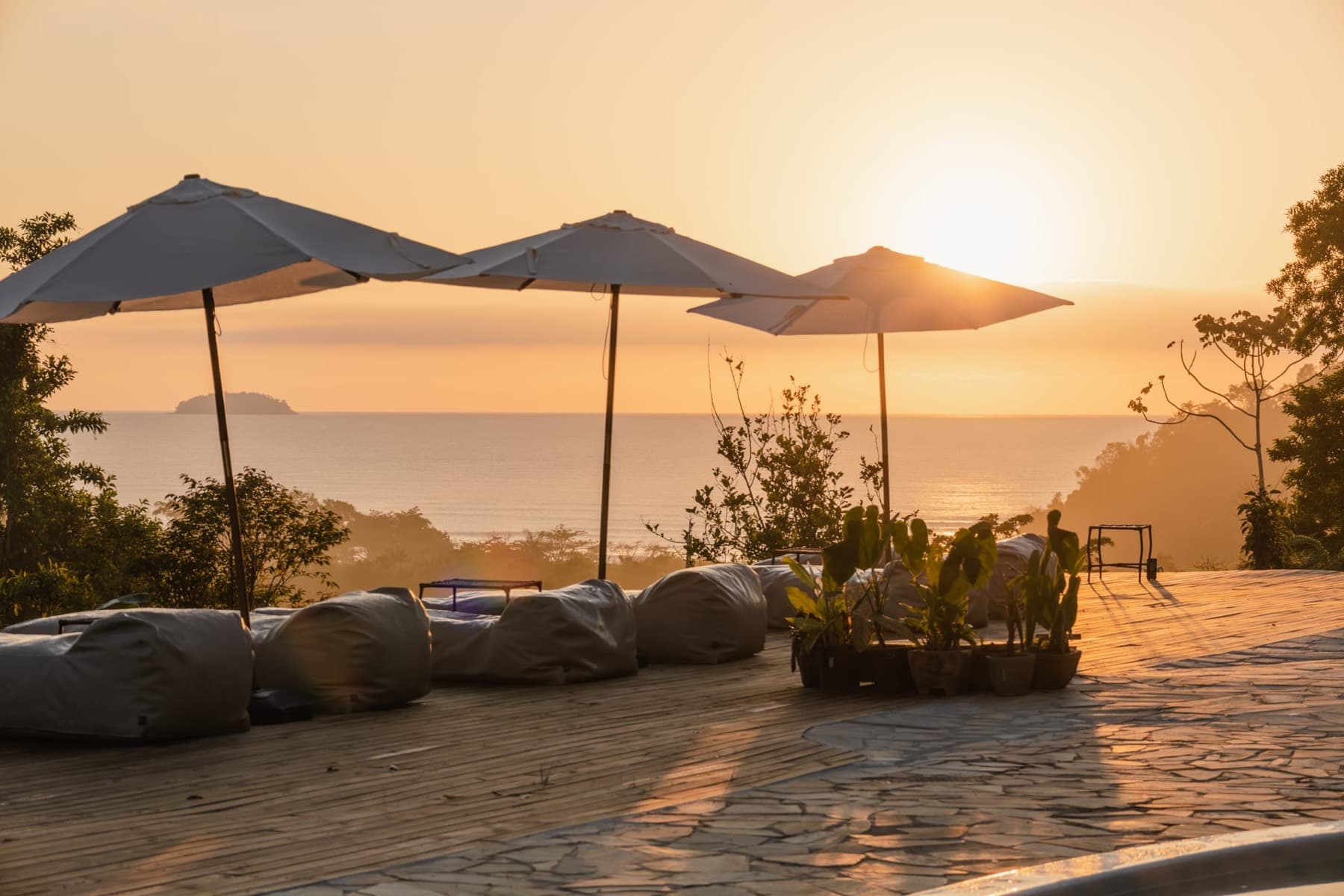 Deck with umbrellas and sea view at sunset